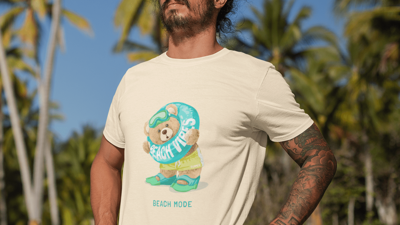 Man wearing a t-shirt with a beach-themed graphic, standing in a tropical setting.